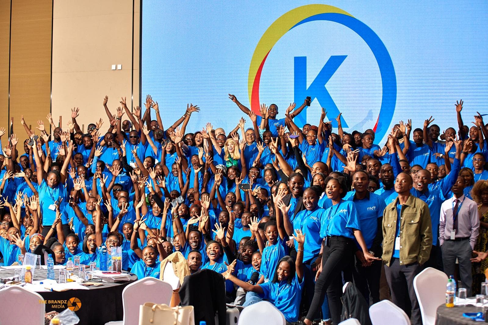 Kectil colleagues gathered together in front of the program mark, cheering.
